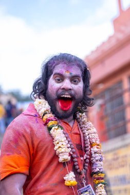Varanasi, Uttar Pradesh, Hindistan - 21 Mart 2024: Masan Holi, manikarnika ghat kutlamaları sırasında yüzü organik renklerle boyanmış kimliği belirsiz bir müridin portresi.