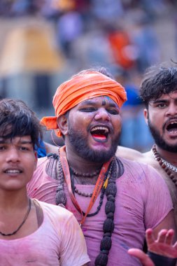 Varanasi, Uttar Pradesh, Hindistan - 21 Mart 2024: Masan Holi, manikarnika ghat kutlamaları sırasında yüzü organik renklerle boyanmış kimliği belirsiz bir grup dindar.