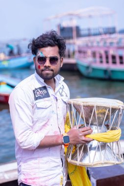 Varanasi, Uttar Pradesh, Hindistan - 21 Mart 2024: Masan Holi, manikarnika ghat kutlamaları sırasında yüzü organik renklerle boyanmış kimliği belirsiz bir müridin portresi.