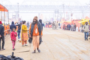 Prayagraj, Uttar Pradesh, Hindistan - 15 Ocak 2025: Mahakumbh, Pereagraj 'da kutsal hamama ibadet etmek ve ayinleri gerçekleştirmek için kumbh mela' ya katılan kutsal erkek ve kadın grubu.