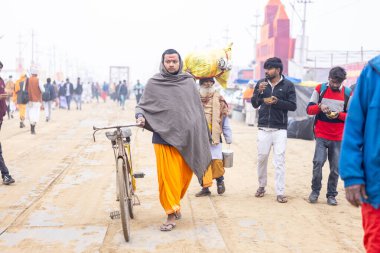 Prayagraj, Uttar Pradesh, Hindistan - 15 Ocak 2025: Mahakumbh, Pereagraj 'da kutsal hamama ibadet etmek ve ayinleri gerçekleştirmek için kumbh mela' ya katılan kutsal erkek ve kadın grubu.