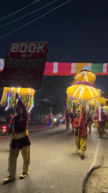 Gaziabad, Uttar Pradesh, Hindistan - 18 Eylül 2025: Elinde dekoratif hafif şemsiyeler tutan bir erkek işçinin portresi.