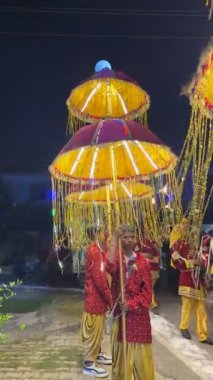 Gaziabad, Uttar Pradesh, Hindistan - 18 Eylül 2025: Elinde dekoratif hafif şemsiyeler tutan bir erkek işçinin portresi.