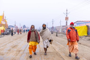 Prayagraj, Uttar Pradesh, Hindistan - 15 Ocak 2025: Mahakumbh, Pereagraj 'daki kumbh mela' ya katılan bir grup dindar, kış sabahı ibadet ve ayinleri gerçekleştirmek için.