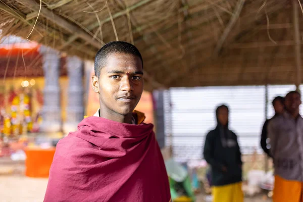 Çadırın içinde duran bornoz giyen genç adam.