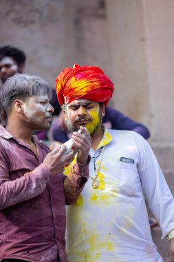 Varanasi, Uttar Pradesh, Hindistan - 21 Mart 2024: Masan Holi, Manikarnika ghat kutlamaları sırasında yüzü organik renklerle boyanmış bir grup dindar..