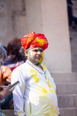 Varanasi, Uttar Pradesh, Hindistan - 21 Mart 2024: Masan Holi, Manikarnika ghat kutlamaları sırasında yüzü organik renklerle boyanmış bir grup dindar..