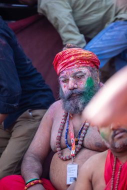 Varanasi, Uttar Pradesh, Hindistan - 21 Mart 2024: Masan Holi, Manikarnika ghat kutlamaları sırasında yüzü organik renklerle boyanmış bir grup dindar..