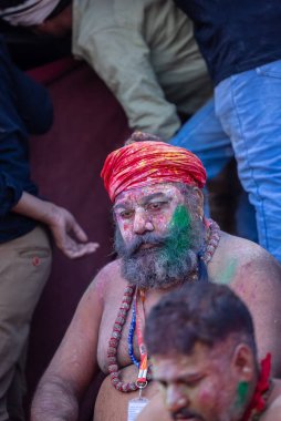 Varanasi, Uttar Pradesh, Hindistan - 21 Mart 2024: Masan Holi, Manikarnika ghat kutlamaları sırasında yüzü organik renklerle boyanmış bir grup dindar..