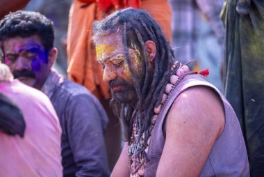 Varanasi, Uttar Pradesh, Hindistan - 21 Mart 2024: Masan Holi, Manikarnika ghat kutlamaları sırasında yüzü organik renklerle boyanmış bir grup dindar..