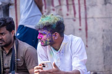 Varanasi, Uttar Pradesh, Hindistan - 21 Mart 2024: Masan Holi, Manikarnika ghat kutlamaları sırasında yüzü organik renklerle boyanmış bir grup dindar..