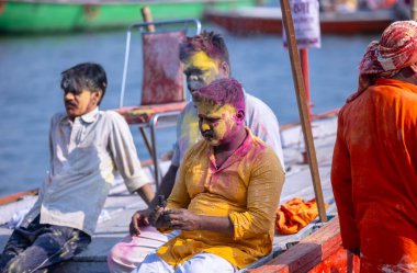 Varanasi, Uttar Pradesh, Hindistan - 21 Mart 2024: Masan Holi, Manikarnika ghat kutlamaları sırasında yüzü organik renklerle boyanmış bir grup dindar..