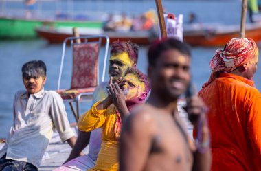 Varanasi, Uttar Pradesh, Hindistan - 21 Mart 2024: Masan Holi, Manikarnika ghat kutlamaları sırasında yüzü organik renklerle boyanmış bir grup dindar..