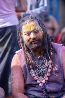 Varanasi, Uttar Pradesh, Hindistan - 21 Mart 2024: Masan Holi, Manikarnika ghat kutlamaları sırasında yüzü organik renklerle boyanmış bir grup dindar..