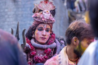 Varanasi, Uttar Pradesh, Hindistan - 21 Mart 2024: Masan Holi, Manikarnika ghat kutlamaları sırasında yüzü organik renklerle boyanmış bir grup dindar..