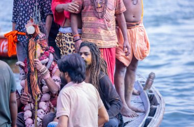 Varanasi, Uttar Pradesh, Hindistan - 21 Mart 2024: Masan Holi, Manikarnika ghat kutlamaları sırasında yüzü organik renklerle boyanmış bir grup dindar..