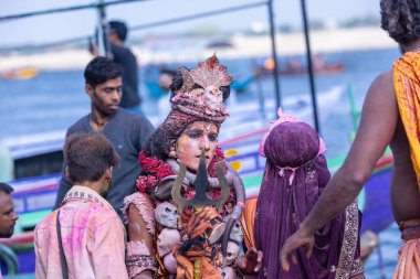 Varanasi, Uttar Pradesh, Hindistan - 21 Mart 2024: Masan Holi, Manikarnika ghat kutlamaları sırasında yüzü organik renklerle boyanmış bir grup dindar..