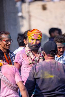 Varanasi, Uttar Pradesh, Hindistan - 21 Mart 2024: Masan Holi, Manikarnika ghat kutlamaları sırasında yüzü organik renklerle boyanmış bir grup dindar..