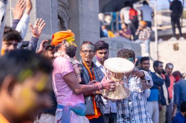 Varanasi, Uttar Pradesh, Hindistan - 21 Mart 2024: Masan Holi, Manikarnika ghat kutlamaları sırasında yüzü organik renklerle boyanmış bir grup dindar..