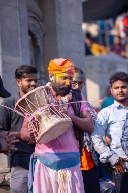 Varanasi, Uttar Pradesh, Hindistan - 21 Mart 2024: Masan Holi, Manikarnika ghat kutlamaları sırasında yüzü organik renklerle boyanmış bir grup dindar..