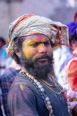 Varanasi, Uttar Pradesh, Hindistan - 21 Mart 2024: Masan Holi, Manikarnika ghat kutlamaları sırasında yüzü organik renklerle boyanmış bir grup dindar..