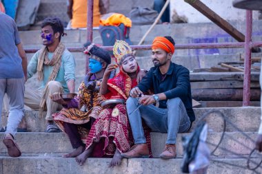 Varanasi, Uttar Pradesh, Hindistan - 21 Mart 2024: Masan Holi, Manikarnika ghat kutlamaları sırasında yüzü organik renklerle boyanmış bir grup dindar..