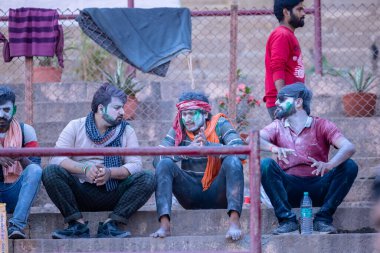 Varanasi, Uttar Pradesh, Hindistan - 21 Mart 2024: Masan Holi, Manikarnika ghat kutlamaları sırasında yüzü organik renklerle boyanmış bir grup dindar..