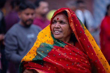 Gaziabad, Uttar Pradesh, Hindistan - 27 Ekim 2025: Chhas Puja, tanımlanamayan Hindu kadın dindar portresi gün batımında toprağa tapan lord güneşinin üzerinde oturarak Chhas ayinlerini gerçekleştiriyor..