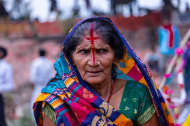 Gaziabad, Uttar Pradesh, Hindistan - 27 Ekim 2025: Chhas Puja, tanımlanamayan Hindu kadın dindar portresi gün batımında toprağa tapan lord güneşinin üzerinde oturarak Chhas ayinlerini gerçekleştiriyor..