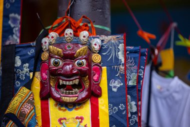 Dekoratif kumaş arkaplanda asılı renkli geleneksel maske