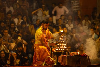Varanasi, Uttar Pradesh, Hindistan - 21 Mart 2024: Ganga aarti, bir grup genç erkek rahip Assi Ghat 'ta geleneksel Hint ayinleri ile geleneksel elbise giyerek akşam üstü Ganga duası yapıyorlar..