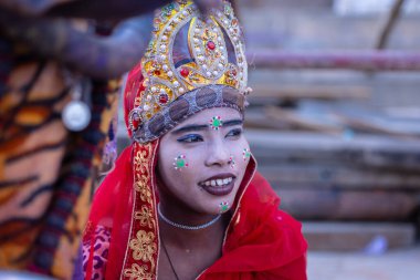 Varanasi, Uttar Pradesh, Hindistan - 20 Ocak 2024: Acı çeken ve Hindu tanrıçası gibi giyinmiş Hintli bir kızın portresi.
