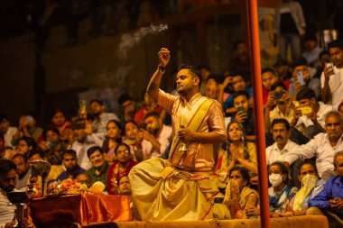 Varanasi, Uttar Pradesh, Hindistan - 21 Mart 2024: Ganga aarti, bir grup genç erkek rahip Assi Ghat 'ta geleneksel Hint ayinleri ile geleneksel elbise giyerek akşam üstü Ganga duası yapıyorlar..