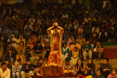 Varanasi, Uttar Pradesh, Hindistan - 21 Mart 2024: Ganga aarti, bir grup genç erkek rahip Assi Ghat 'ta geleneksel Hint ayinleri ile geleneksel elbise giyerek akşam üstü Ganga duası yapıyorlar..
