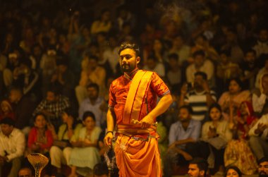 Varanasi, Uttar Pradesh, Hindistan - 21 Mart 2024: Ganga aarti, bir grup genç erkek rahip Assi Ghat 'ta geleneksel Hint ayinleri ile geleneksel elbise giyerek akşam üstü Ganga duası yapıyorlar..