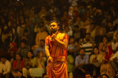 Varanasi, Uttar Pradesh, Hindistan - 21 Mart 2024: Ganga aarti, bir grup genç erkek rahip Assi Ghat 'ta geleneksel Hint ayinleri ile geleneksel elbise giyerek akşam üstü Ganga duası yapıyorlar..