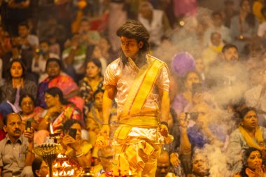 Varanasi, Uttar Pradesh, Hindistan - 21 Mart 2024: Ganga aarti, bir grup genç erkek rahip Assi Ghat 'ta geleneksel Hint ayinleri ile geleneksel elbise giyerek akşam üstü Ganga duası yapıyorlar..