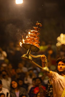 Varanasi, Uttar Pradesh, Hindistan - 21 Mart 2024: Ganga aarti, bir grup genç erkek rahip Assi Ghat 'ta geleneksel Hint ayinleri ile geleneksel elbise giyerek akşam üstü Ganga duası yapıyorlar..