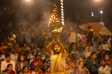 Varanasi, Uttar Pradesh, Hindistan - 21 Mart 2024: Ganga aarti, bir grup genç erkek rahip Assi Ghat 'ta geleneksel Hint ayinleri ile geleneksel elbise giyerek akşam üstü Ganga duası yapıyorlar..