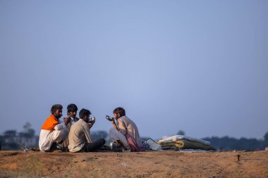 Puşkar, Rajasthan, Hindistan - 11 Kasım 2024: Geleneksel beyaz giysili rajasthani erkek portresi çöl panayırında renkli türbanla deve pazarında deve ticareti yaparken.