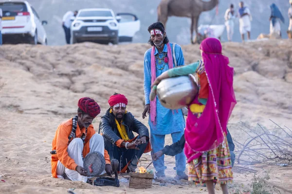 Puşkar, Rajasthan, Hindistan - 11 Kasım 2024: Geleneksel beyaz giysili rajasthani erkek portresi çöl panayırında renkli türbanla deve pazarında deve ticareti yaparken.