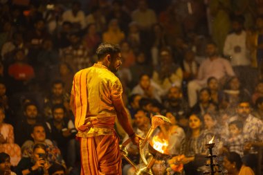 Varanasi, Uttar Pradesh, Hindistan - 21 Mart 2024: Ganga aarti, bir grup genç erkek rahip Assi Ghat 'ta geleneksel Hint ayinleri ile geleneksel elbise giyerek akşam üstü Ganga duası yapıyorlar..