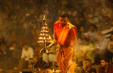Varanasi, Uttar Pradesh, Hindistan - 21 Mart 2024: Ganga aarti, bir grup genç erkek rahip Assi Ghat 'ta geleneksel Hint ayinleri ile geleneksel elbise giyerek akşam üstü Ganga duası yapıyorlar..