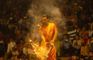 Varanasi, Uttar Pradesh, Hindistan - 21 Mart 2024: Ganga aarti, bir grup genç erkek rahip Assi Ghat 'ta geleneksel Hint ayinleri ile geleneksel elbise giyerek akşam üstü Ganga duası yapıyorlar..