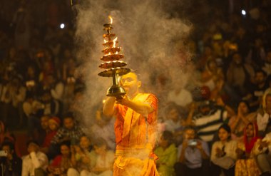 Varanasi, Uttar Pradesh, Hindistan - 21 Mart 2024: Ganga aarti, bir grup genç erkek rahip Assi Ghat 'ta geleneksel Hint ayinleri ile geleneksel elbise giyerek akşam üstü Ganga duası yapıyorlar..