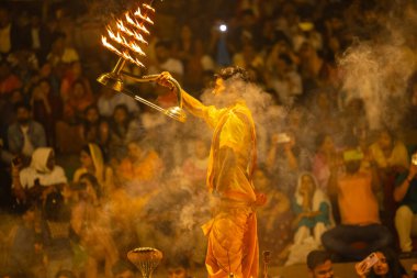 Varanasi, Uttar Pradesh, Hindistan - 21 Mart 2024: Ganga aarti, bir grup genç erkek rahip Assi Ghat 'ta geleneksel Hint ayinleri ile geleneksel elbise giyerek akşam üstü Ganga duası yapıyorlar..
