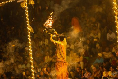 Varanasi, Uttar Pradesh, Hindistan - 21 Mart 2024: Ganga aarti, bir grup genç erkek rahip Assi Ghat 'ta geleneksel Hint ayinleri ile geleneksel elbise giyerek akşam üstü Ganga duası yapıyorlar..