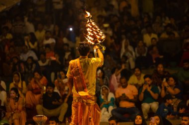 Varanasi, Uttar Pradesh, Hindistan - 21 Mart 2024: Ganga aarti, bir grup genç erkek rahip Assi Ghat 'ta geleneksel Hint ayinleri ile geleneksel elbise giyerek akşam üstü Ganga duası yapıyorlar..