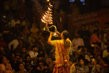 Varanasi, Uttar Pradesh, Hindistan - 21 Mart 2024: Ganga aarti, bir grup genç erkek rahip Assi Ghat 'ta geleneksel Hint ayinleri ile geleneksel elbise giyerek akşam üstü Ganga duası yapıyorlar..