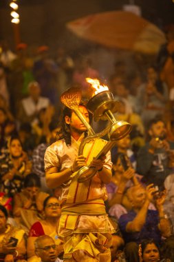 Varanasi, Uttar Pradesh, Hindistan - 21 Mart 2024: Ganga aarti, bir grup genç erkek rahip Assi Ghat 'ta geleneksel Hint ayinleri ile geleneksel elbise giyerek akşam üstü Ganga duası yapıyorlar..